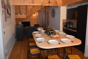 a large wooden table with chairs in a room at VAUJANYLOCATIONS - Ameythistes B8 in Vaujany