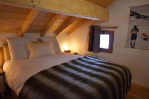 a bedroom with a bed in a room with wooden ceilings at VAUJANYLOCATIONS - Les Amethystes in Vaujany