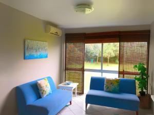 a living room with two blue chairs and a window at LA Ballito in Ballito