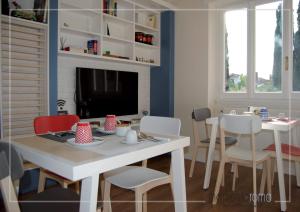 - un salon avec une table, des chaises et une télévision dans l'établissement Momentoroma b&b, à Ciampino