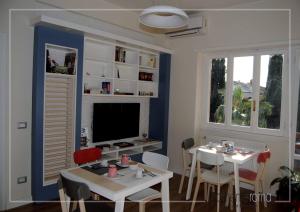 - un salon avec une télévision, une table et des chaises dans l'établissement Momentoroma b&b, à Ciampino