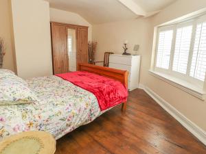 a bedroom with a bed and a large window at Heath Corner in Knutsford
