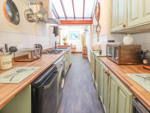 a kitchen with a sink and a stove top oven at Heath Corner in Knutsford