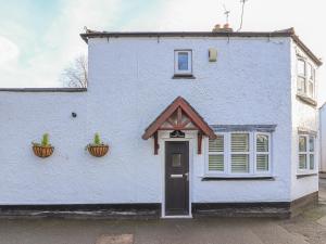 a white house with two plants on the side of it at Heath Corner in Knutsford