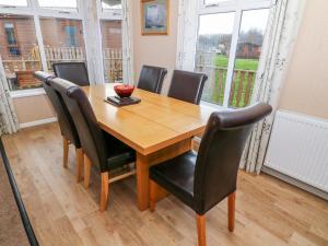 a wooden dining room table with chairs and a bowl on it at 16 Sherwood Lodge in Carnforth