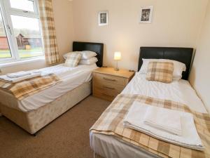 two beds sitting next to each other in a bedroom at 16 Sherwood Lodge in Carnforth
