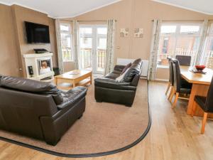 a living room with two couches and a table at 16 Sherwood Lodge in Carnforth