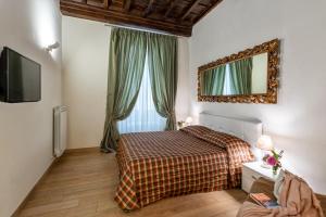 um quarto com uma cama e um espelho na parede em Windows On Florence em Florença