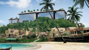 un edificio en una colina con palmeras y una playa en Taj Cidade de Goa Horizon, Goa en Panaji