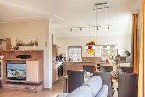 TV a/nebo společenská místnost v ubytování Ferienhaus Strandgut - Reetdachhaus in Strandnähe