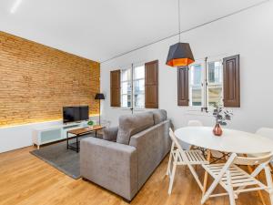- un salon avec un canapé et une table dans l'établissement Sant Pau Ramblas Apartments Serennia, à Barcelone