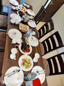 una larga mesa de madera con platos de comida. en Hotel Exotic - 5 min walk from Golden Temple, en Amritsar