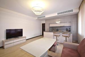 a living room with a white table and a tv at Northern Avenue 2 bedrooms New and Modern apartment in New Elite Building HH600 in Yerevan