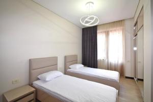 a bedroom with two beds and a window at Northern Avenue 2 bedrooms New and Modern apartment in New Elite Building HH600 in Yerevan