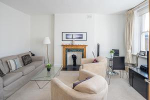 a living room with two couches and a fireplace at ALTIDO Charming 2-bed flat in Kensington, nearby tube in London