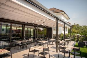 a restaurant with tables and chairs on a patio at Auberge de la Tour in Trélex