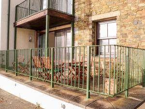 a balcony on the side of a building with chairs at Ocean Blue in Penzance