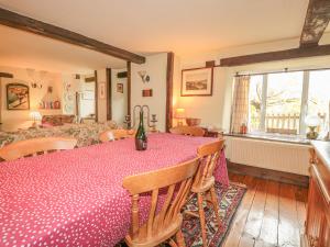 a dining room with a table and chairs and a window at Little End in Stroud