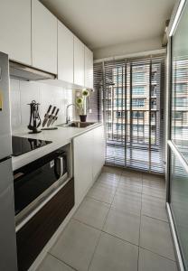 a kitchen with white cabinets and a large window at First Choice Suites SHA Plus Extra in Hua Hin