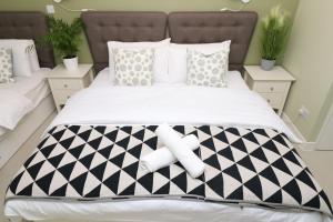 a bed with a black and white patterned bedspread at The Spinney in Bracknell