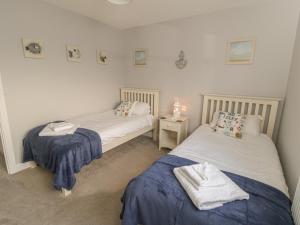 ein Schlafzimmer mit 2 Betten und einem Tisch mit einer Lampe in der Unterkunft Sandy Corner in Filey