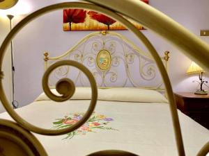 uma cama com uma colcha branca com flores em A Casa di Nonno Dorgali em Dorgali