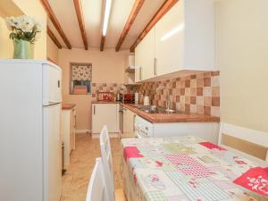 a kitchen with a table and a white refrigerator at Summerfield Farm Cottage in York