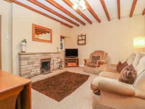 a living room with two couches and a fireplace at Summerfield Farm Cottage in York