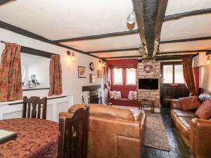 een woonkamer met een bank en een tafel bij Combe Cottage in Stroud