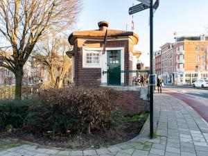 een klein bakstenen huis met een groene deur op een straat bij SWEETS - Willemsbrug in Amsterdam