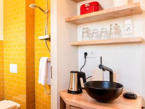 een badkamer met een zwarte kom op een aanrecht naast een douche bij SWEETS - Willemsbrug in Amsterdam