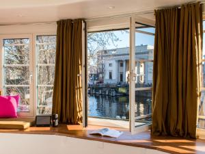 Zimmer mit einem großen Fenster mit Blick auf das Wasser in der Unterkunft SWEETS - Willemsbrug in Amsterdam