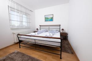 Apartmani Špoljar في زوبانيا: غرفة نوم بسرير في غرفة بيضاء