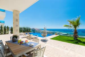 Blue Horizon Luxury Villas في فالاسارنا: فناء مع طاولة وكراسي والمحيط