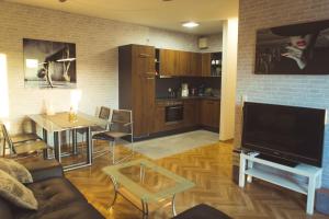 a living room with a couch and a table and a television at Apartment New York in Mühlhausen