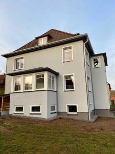 a large white house with windows and a yard at FeWoWa _ FerienWohnungen Walter in Bad Sachsa