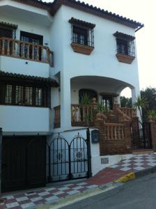 a white house with a gate and a balcony at villa verónica in Arriate