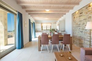 a dining room and living room with a stone wall at Blue Horizon Luxury Villas in Falasarna