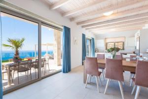 a dining room with a table and a view of the ocean at Blue Horizon Luxury Villas in Falasarna