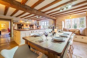 una cucina con un grande tavolo in legno con sedie di Grove Farm House a Thornham Magna