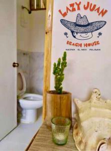 een badkamer met een toilet en een cactus op een tafel bij Lazy Juan Beach House Nacpan in El Nido