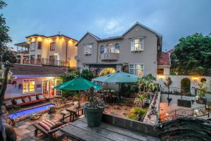 a large house with a patio and a swimming pool at Acorn B&B in Durban in Durban