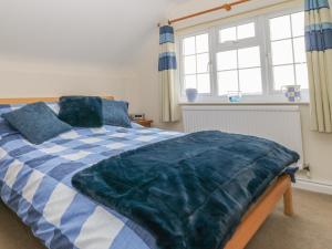 a bedroom with a blue and white comforter on a bed at Hanging Hill Farm Cottage in Malton