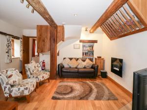a living room with a leather couch and chairs at Chapel Cottage in Stonehouse