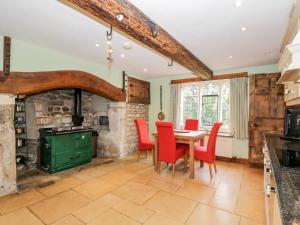 uma cozinha com uma mesa, cadeiras e um fogão em Chapel House em Stonehouse