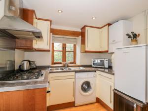 a kitchen with a washer and dryer at Chapel Cottage in Stonehouse