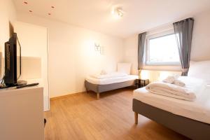 a hotel room with two beds and a television at FeWo Markdorf in Markdorf