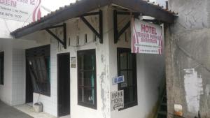 ein Gebäude mit Schildern an der Seite in der Unterkunft Hotel Teratai Putih in Baturaden