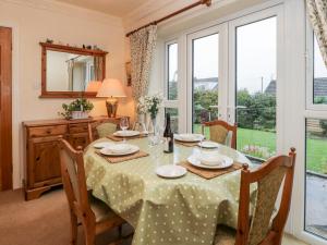 een eetkamer met een tafel, stoelen en ramen bij Sanderling in Scarborough
