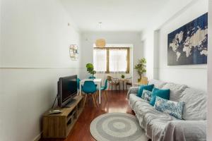 a living room with a couch and a tv at Lodging Apartments Illa Diagonal in Barcelona